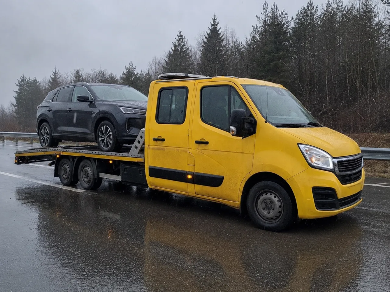 Holowanie srebrnego SUV-a na lawecie w deszczu – Lubin